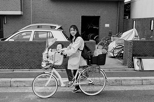 homepage image for Japan album, depicting a woman and child on a bike